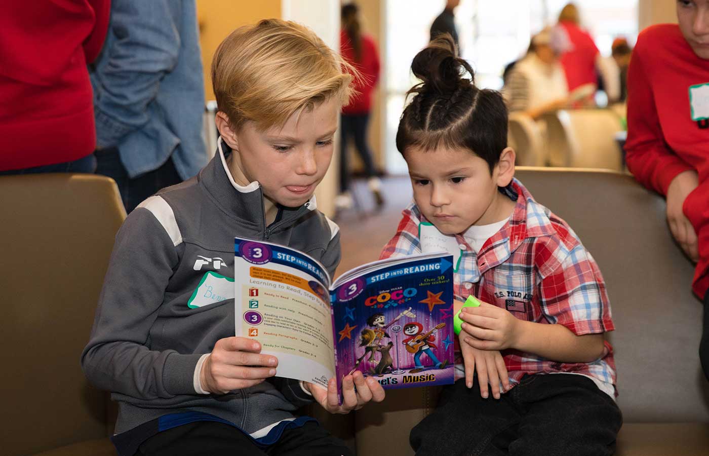 Two children reading a book to support academic success