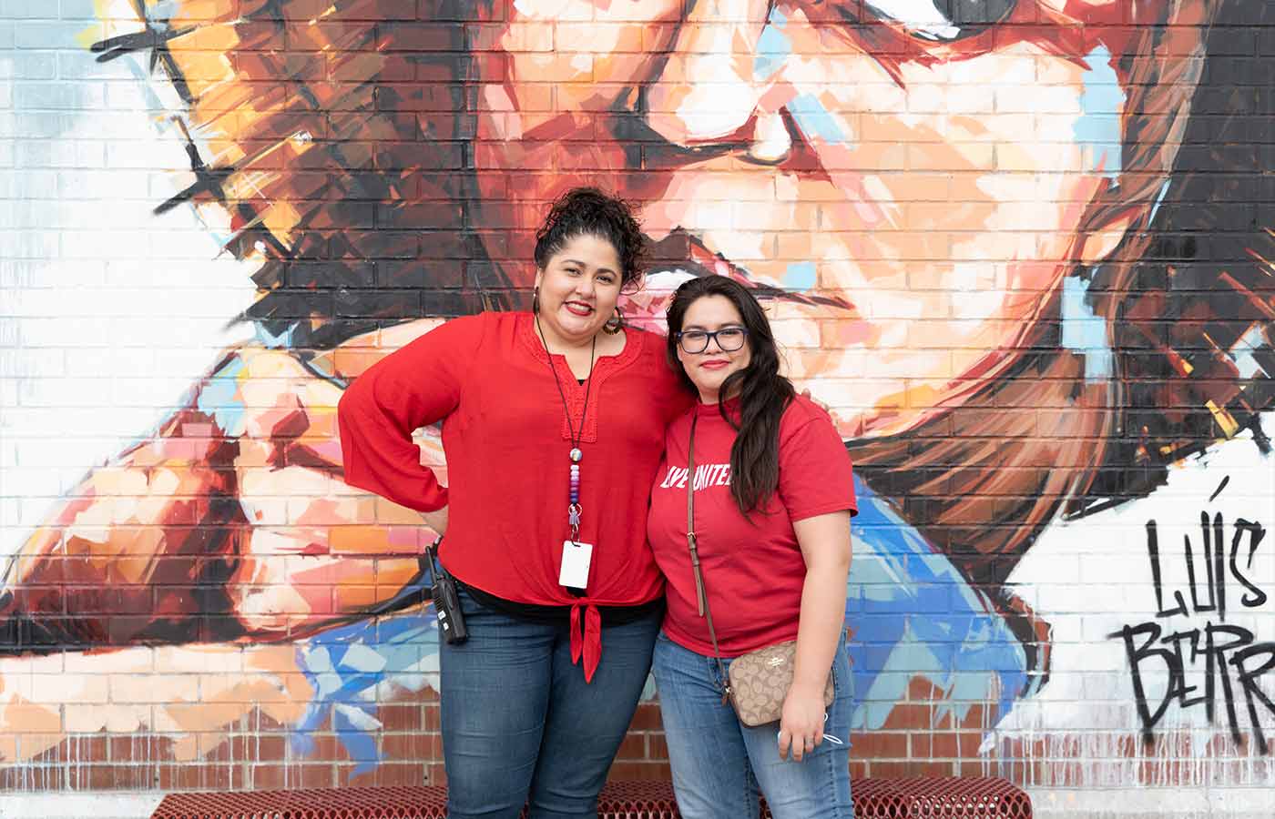 principal of garden place academy in denver with UFS community advocate in front of school mural