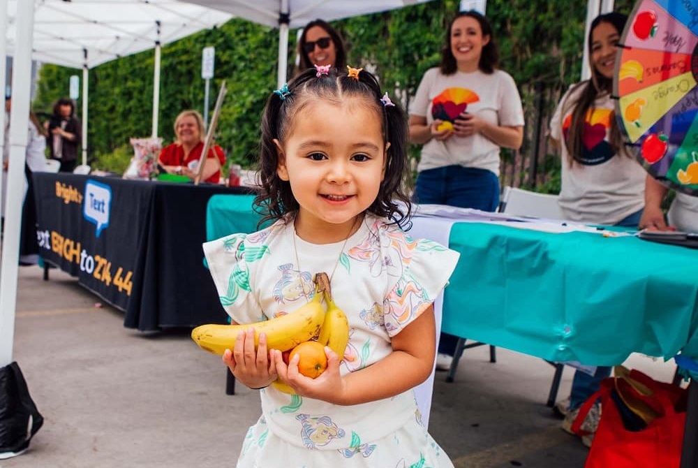 A little girl in Denver receiving supplies from Mile High United Way