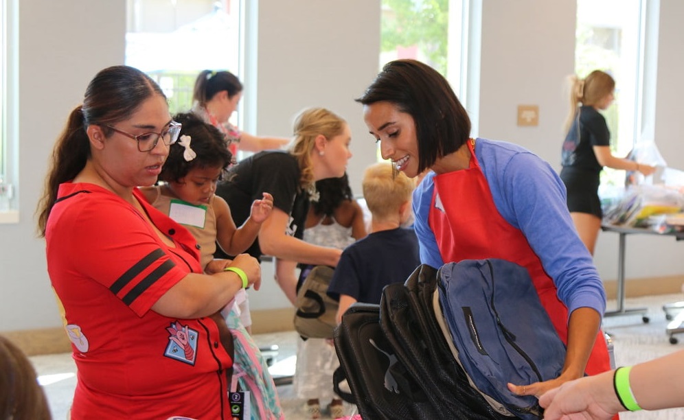 Distributing backpacks at our 2024 Back to School Bash